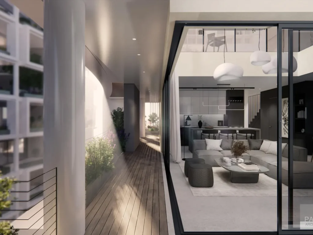 View from a covered terrace into a light-filled living room through full-height sliding glass doors